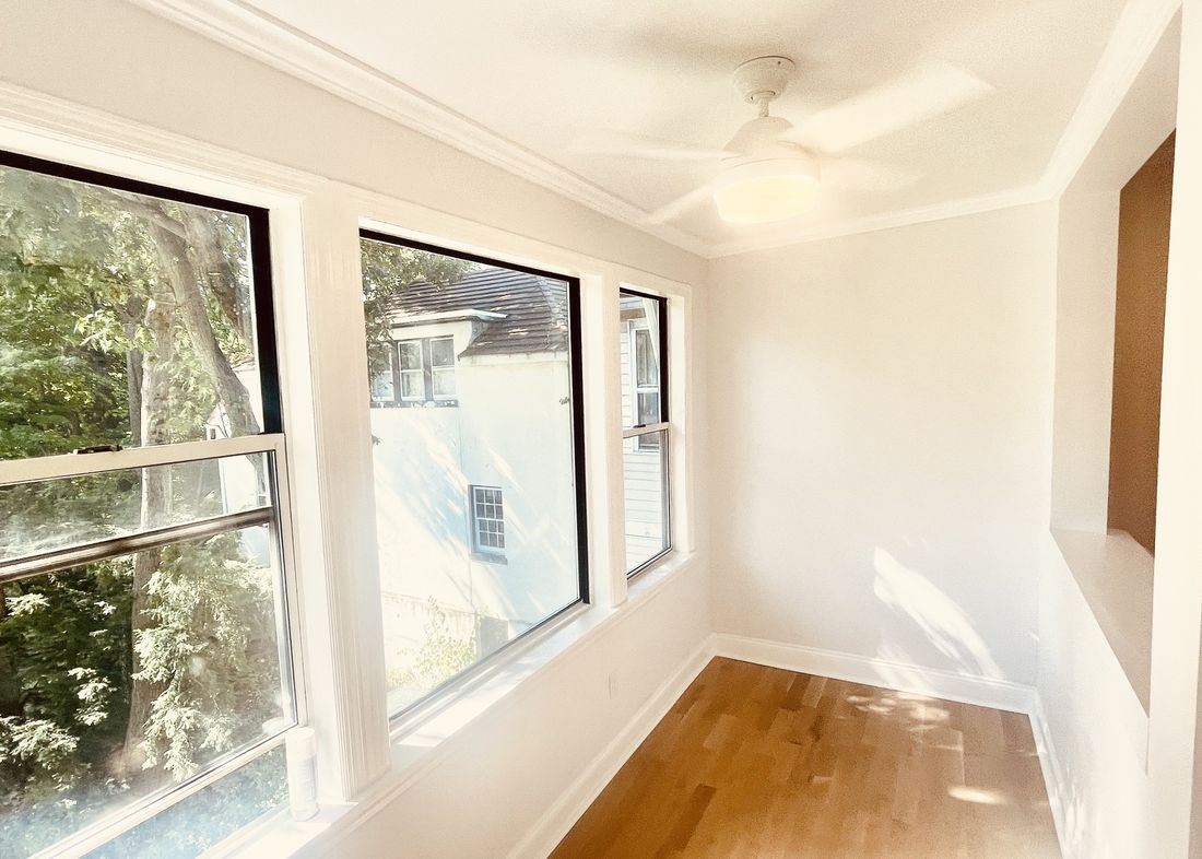 The same sun room rebuilt with clean walls, new trim and refinished floors