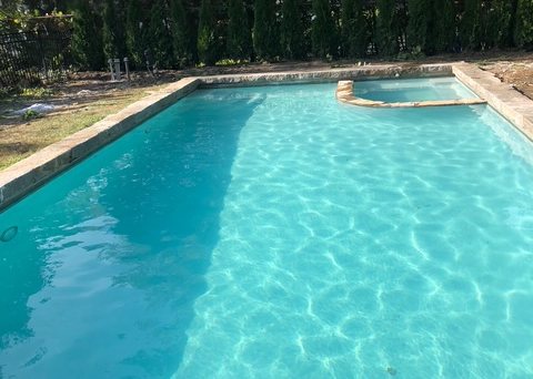 The same swimming pool restored, refilled and back in service with new plantings