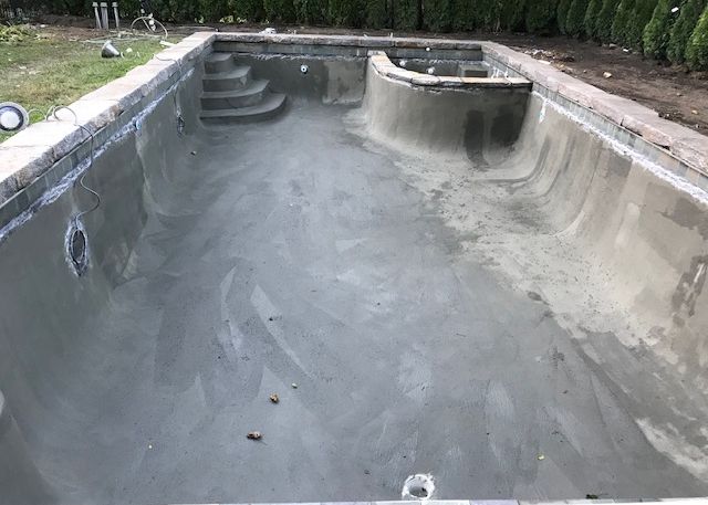 Swimming pool stripped to bare plaster before restoration