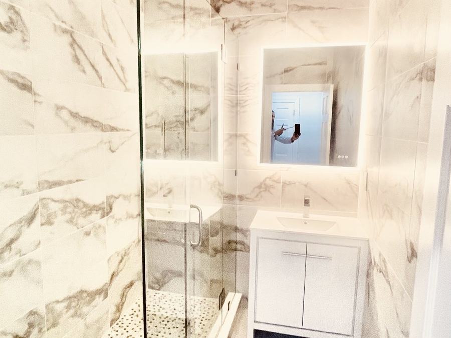 Renovated marble bathroom with frameless glass shower