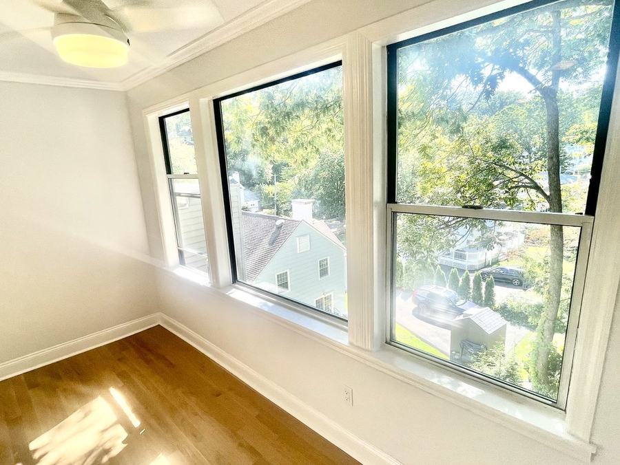 Bright bedroom with corner windows and hardwood floors