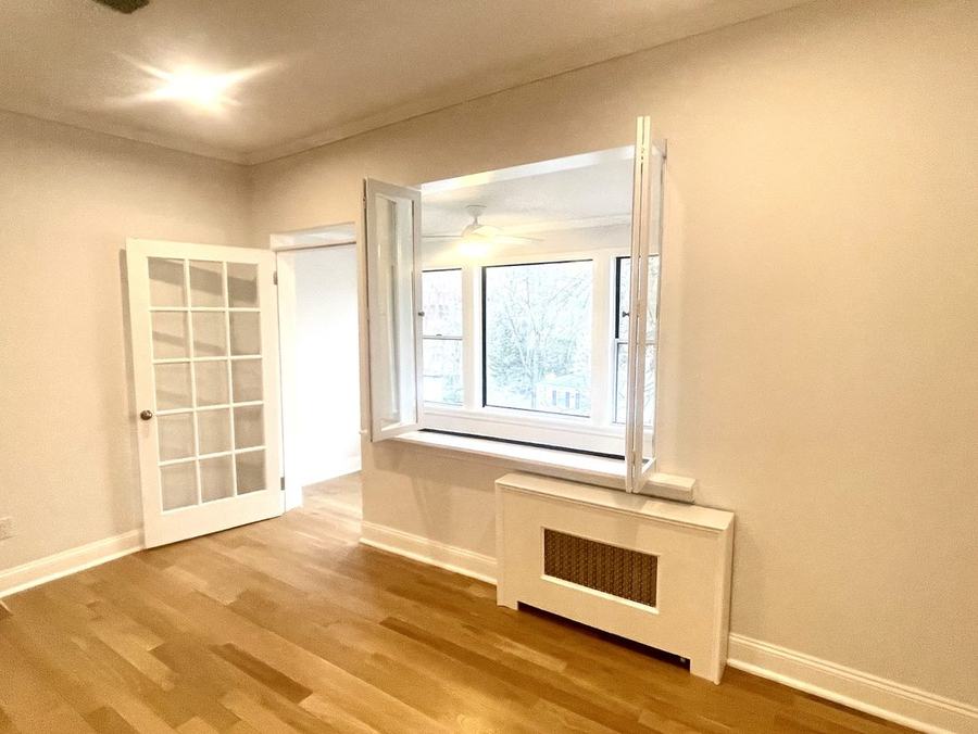 Room with French door, bay window and radiator enclosure