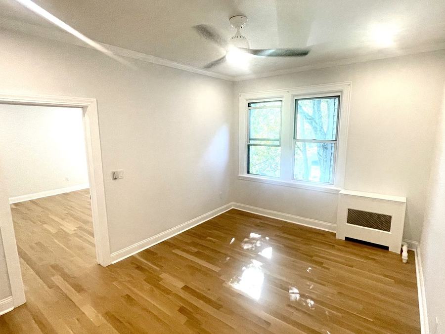 Bedroom with refinished hardwood floors ready for a tenant