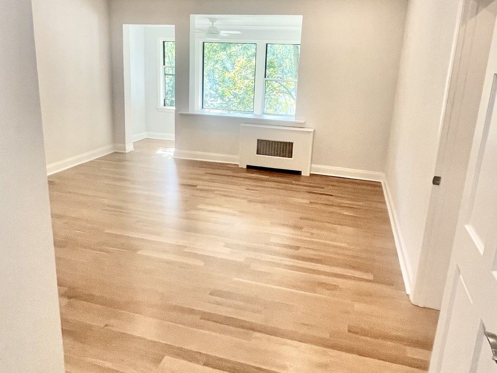 Refinished hardwood flooring running through a renovated apartment